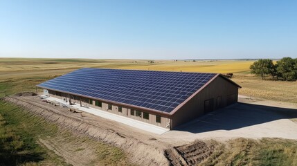 Obraz premium Solar panels installed on building roof in open field with clear sky