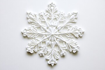 Ornate white snowflake decoration against a plain white background