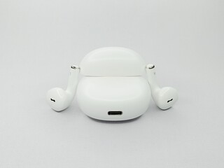 A pair of white wireless earphones with an open case, featuring a modern, elegant and minimalist...