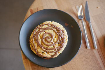 Tasty dessert on a plate with swirling chocolate topping