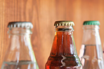 Vintage glass bottles with metal caps on wooden background