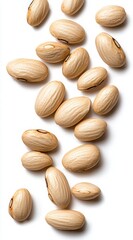 Obraz premium A collection of light-colored, oval-shaped seeds scattered on a white background, showcasing their smooth texture and distinct markings.