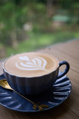 A Cup of Calm in Green Serenity. A crafted latte with latte art and cappucinno on wooden table.