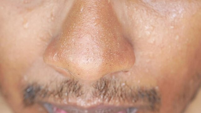 Close-up view of a man showing facial expressions with perspiration