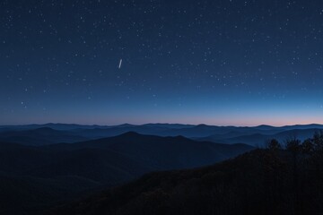 Naklejka premium Starry night sky over a mountain range at twilight.