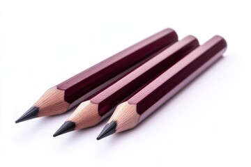 Naklejka premium Three dark red pencils with graphite tips, arranged on a white background.