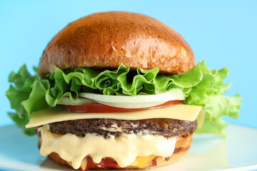 Plate with tasty burger on blue background, closeup