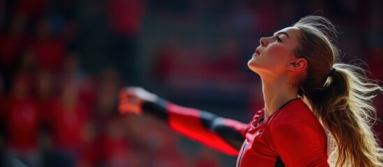 Female volleyball player looking up in celebration after a point.