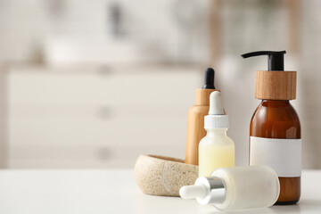 Bottles of cosmetic products and stone soap box on table in bathroom, closeup