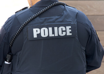 Close up on Police title logo on back of flack jacket.