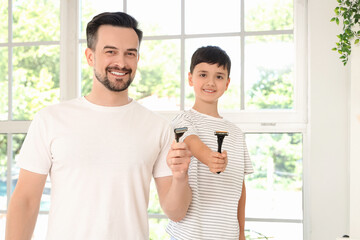 Happy father and his little son with razors in bathroom