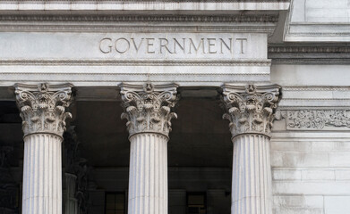 Obraz premium Government carved in stone on facade of downtown building. AI generative fill used.