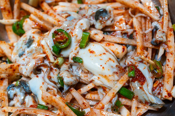 raw oysters seasoned with spicy sauces, vegetables and other ingredients