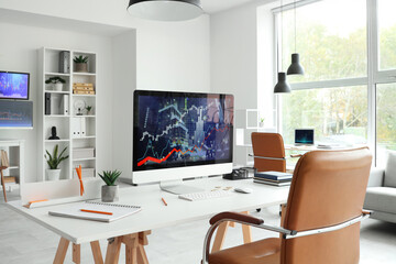 Fototapeta premium Computer monitor with stock data on trader's table in office