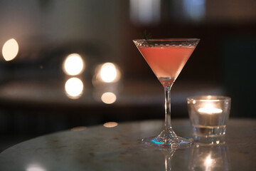 cocktail and candlelight on night bar table with bokeh