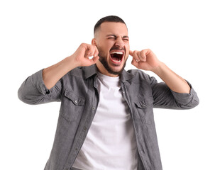 Young man suffering from loud noise on white background