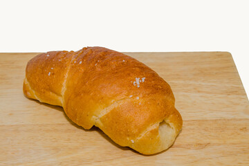 A single piece of baked bread on a wooden board in a simple presentation