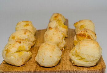 Close-up of bread rolls on a wooden board with a plain white background