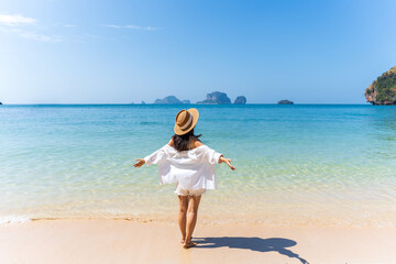 Young Asian woman relaxing and enjoying at beautiful white sand beach on sunny day, Travel on...