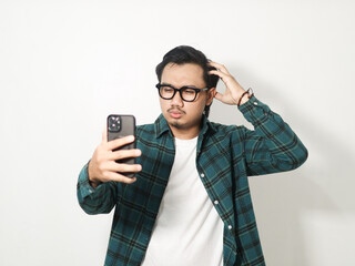 Adult Asian man showing stress expression while holding mobile phone isolated on white background