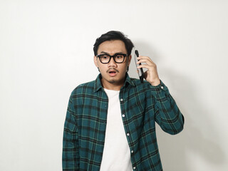 Young Asian man expressing frustration while on a phone call