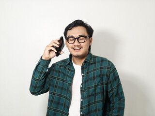 Adult Asian man smiling while answering a phone call isolated on white background