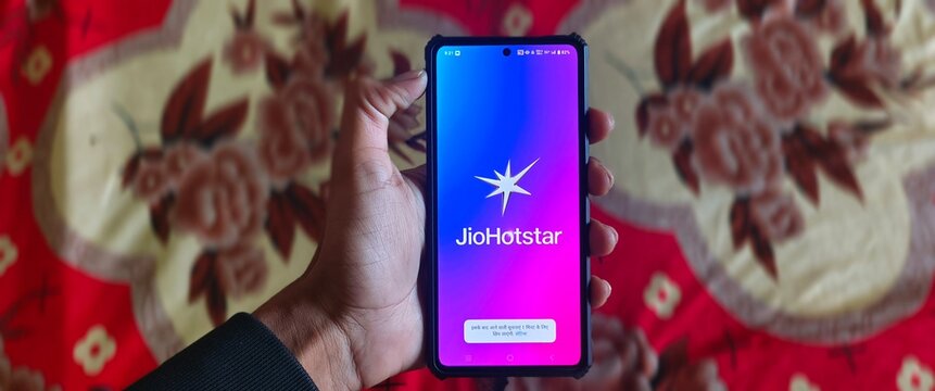 New Delhi, India - February 15 2025. Jio hotstar app icon on mobile screen, a person using Jiostar after merge of Jiocinema and Hotstar. 