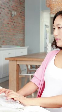 Pregnant asian woman using computer