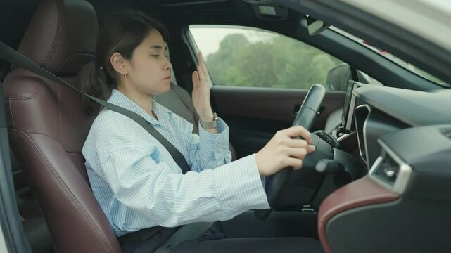 woman feeling sleepy and yawn during drive car long time. Asian girl tired and fatigue having headache after driving car in traffic jam. Sleep, stretching and safety concept