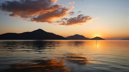 sunset over the ocean with mountains in the distance