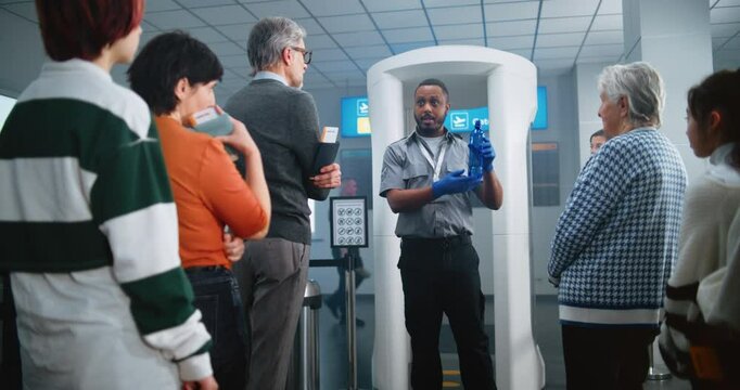 Airport Security Checkpoint: African American Security Officer Gives Instructions to Diverse People, Passengers About TSA Screening Procedures for Boarding Flight. Queue of Tourists Going on Trips.