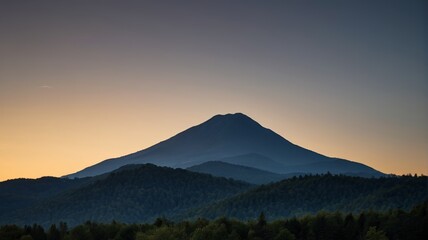 mountains with a few trees in the foreground and a sunset in the background