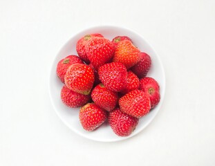 strawberries in a bowl on a white background. 