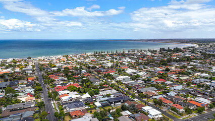 Obraz premium Aerial view of Seaholme, a bayside suburb of Melbourne, Australia, overlooking Altona Beach, suburban residential streets, and the coastline of Port Phillip Bay in the western suburbs.