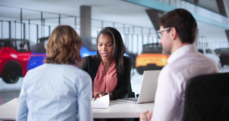 New car buyers signing contract with dealership salesperson