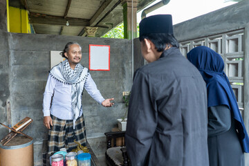 Lebaran homecoming in his hometown greet each other apologizing with friends during the Eid. adult man receives young man's guest during Eid. entertaining guests 