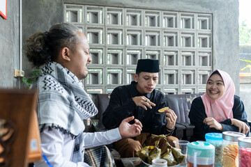 Lebaran homecoming in his hometown greet each other apologizing with friends during the Eid. adult man receives young man's guest during Eid. entertaining guests 
