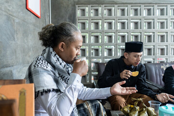 Lebaran homecoming in his hometown greet each other apologizing with friends during the Eid. adult man receives young man's guest during Eid. entertaining guests 