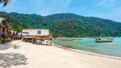 Serene Surin Island in Thailand showcases lush landscapes and vibrant fishing boats by the shore