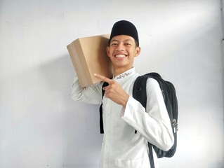 Muslim man carrying cardboard box and black bag with happy face