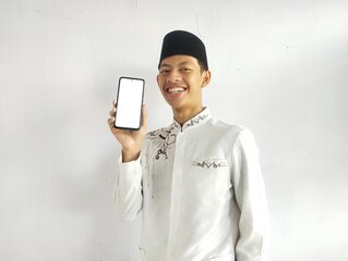 Moslem Asian man smiling and showing blank mobile phone screen