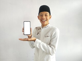 Moslem Asian man smiling and showing blank mobile phone screen