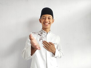 Moslem Asian man smiling friendly when offering hand shake
