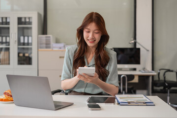 Female working on desk office with using a calculator to calculate tax.