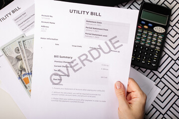Overdue Utility Bill Notice in hand, energy and water bill statement, overdue charge and monthly budget concern