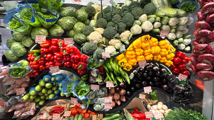 Colorful array of fresh vegetables beautifully arranged in market. Bright red peppers, green lettuce, yellow bell peppers, cauliflowers, cabbages. Display healthy organic produce, nutrition culinary.