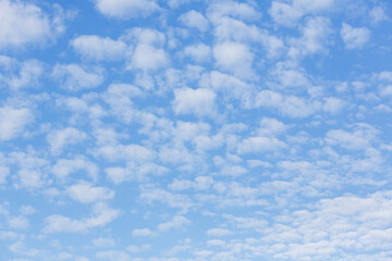A vast blue sky with scattered white clouds, creating a peaceful and serene atmosphere, perfect for backgrounds and nature themes.