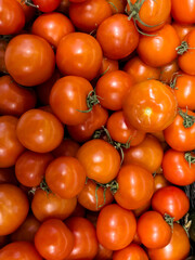 Fresh, ripe tomatoes piled together at a local market, showcasing vibrant colors and textures