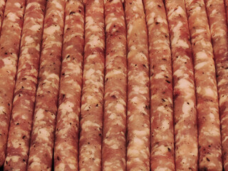 Freshly prepared sausages lined up on a wooden surface for an upcoming barbecue or culinary event