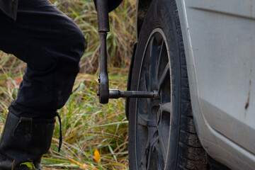 Changing a wheel. Close-up of loosening and tightening wheel bolts. Seasonal tire change. Part of...